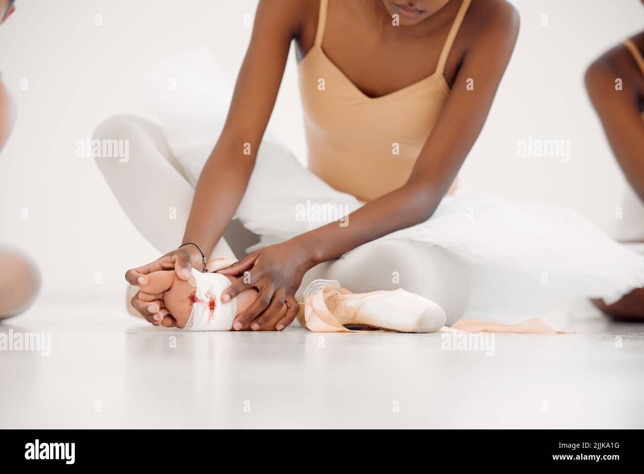 Nessun dolore, nessun guadagno. Una ballerina irriconoscibile che si lega alle sue scarpe pointe. Foto Stock