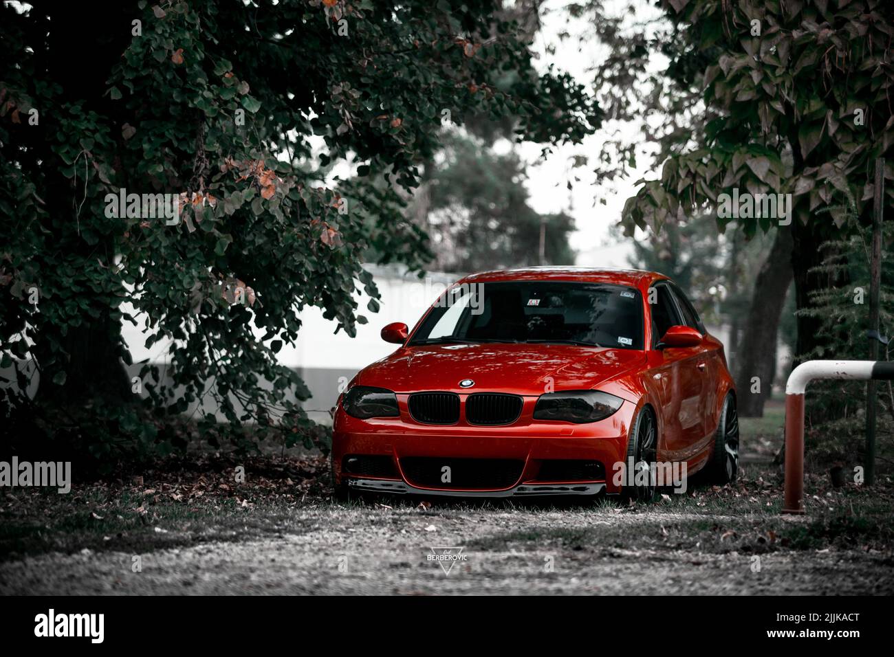 Una vettura di lusso rossa sintonizzata e abbassata BMW parcheggiata sulla strada Foto Stock