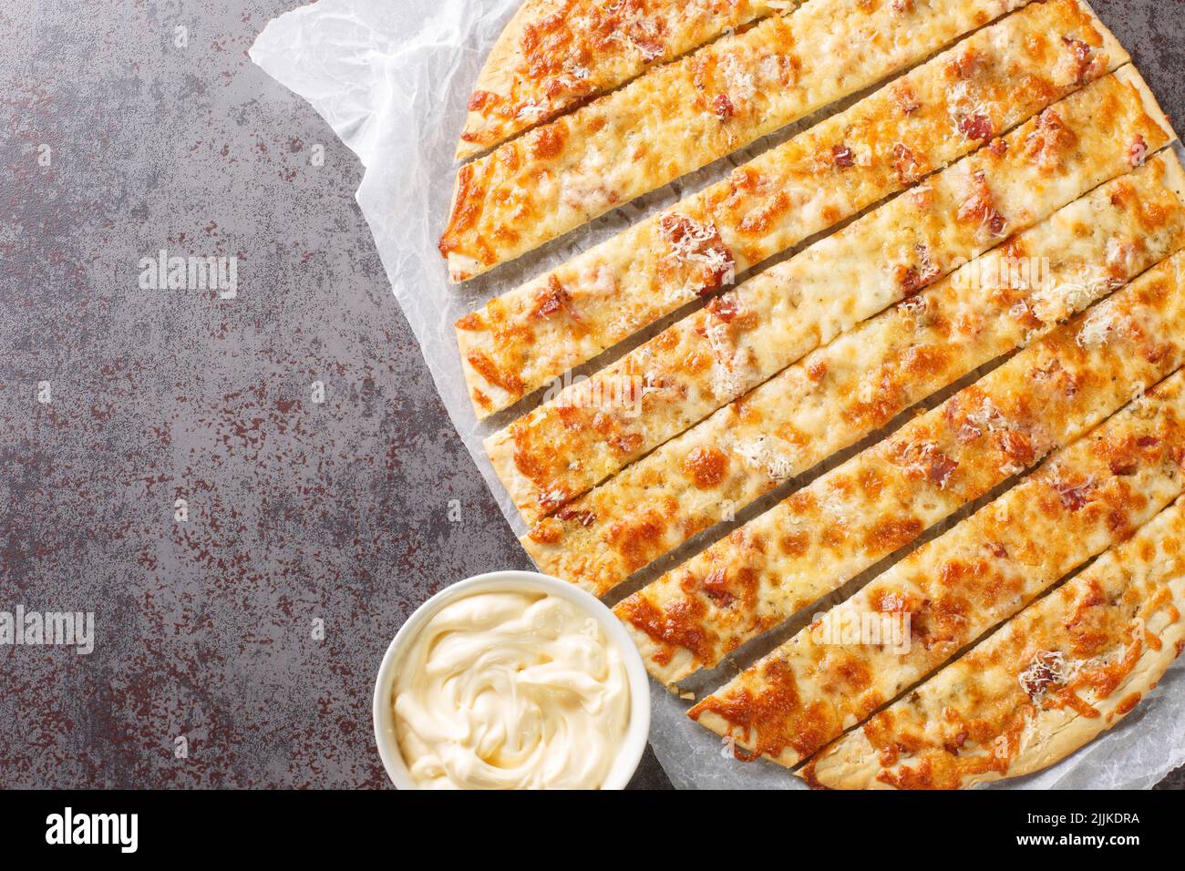 Pizzeria canadese barrette aglio e Donair Sauce primo piano su carta sul tavolo. Vista orizzontale dall'alto Foto Stock