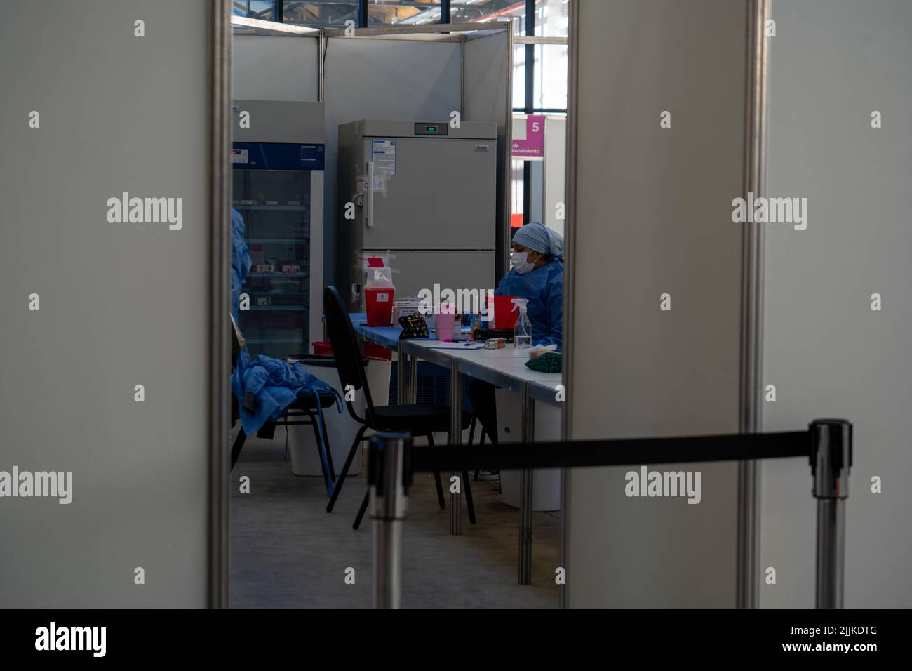 Foto scattata dall'esterno di una stanza dove le infermiere sono viste pronte a vaccinare, durante la pandemia Foto Stock