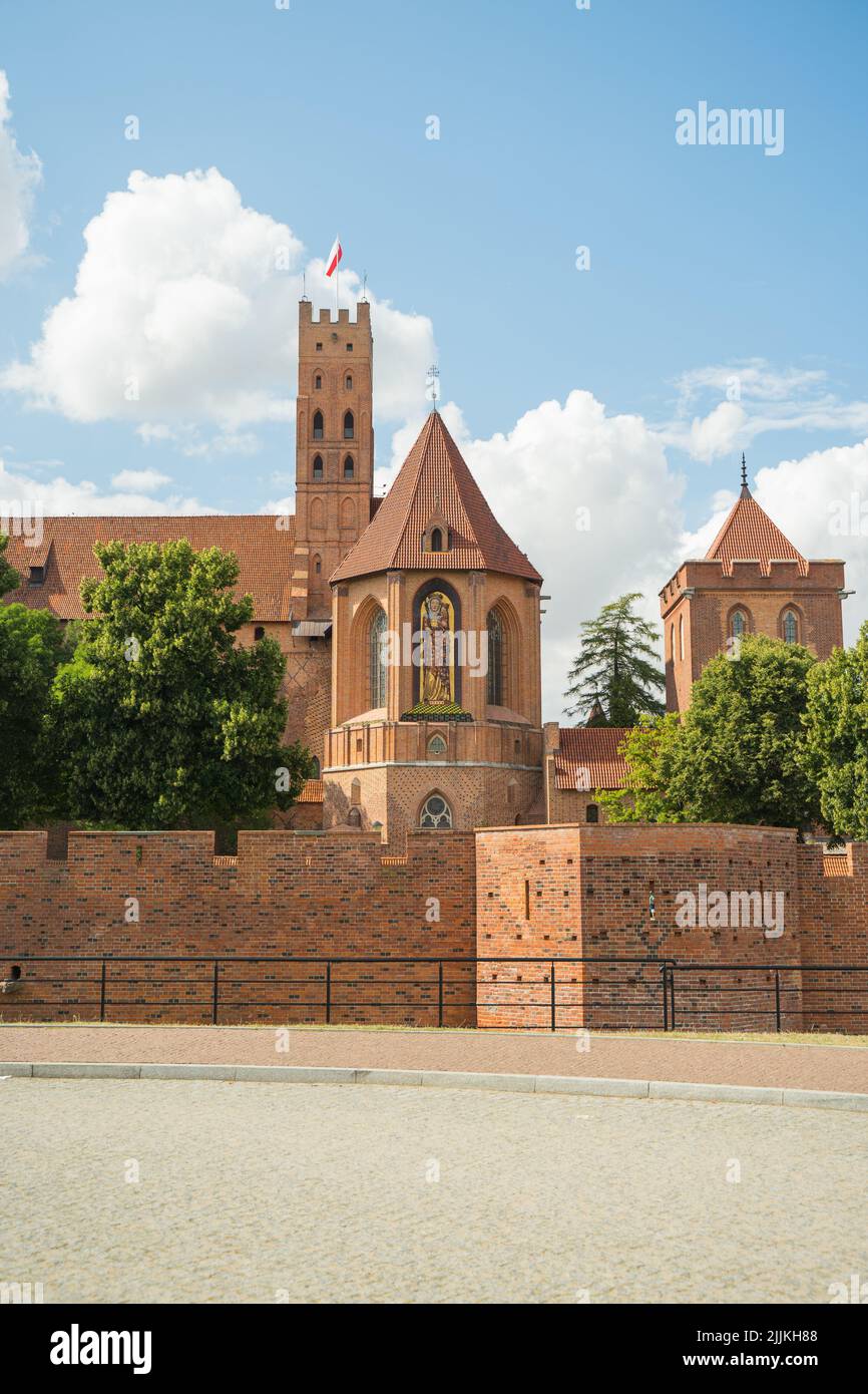 Vista esterna dell'alto castello di Malbork con una torre visibile e la cappella della Beata Vergine Maria Foto Stock