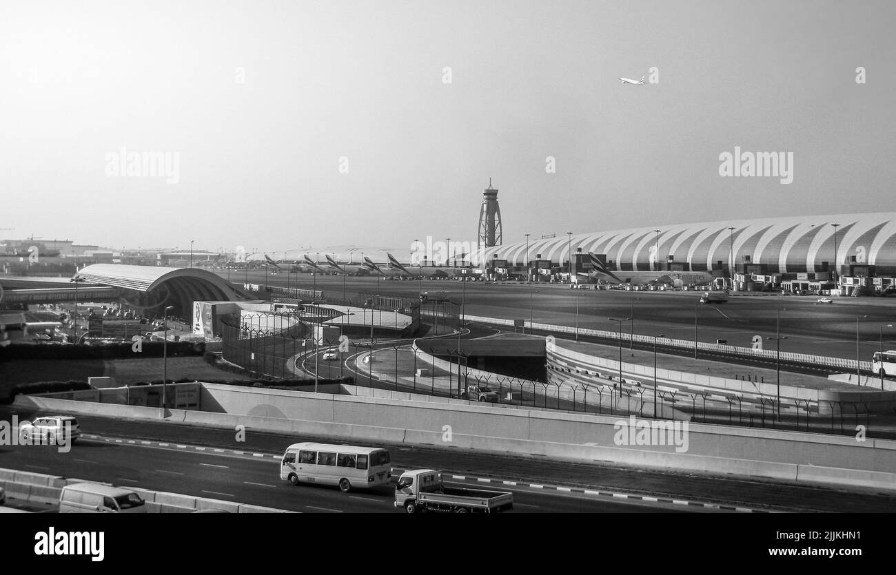 Una vista di una strada trafficata con auto e aeroplani all'Aeroporto Internazionale di Dubai Foto Stock