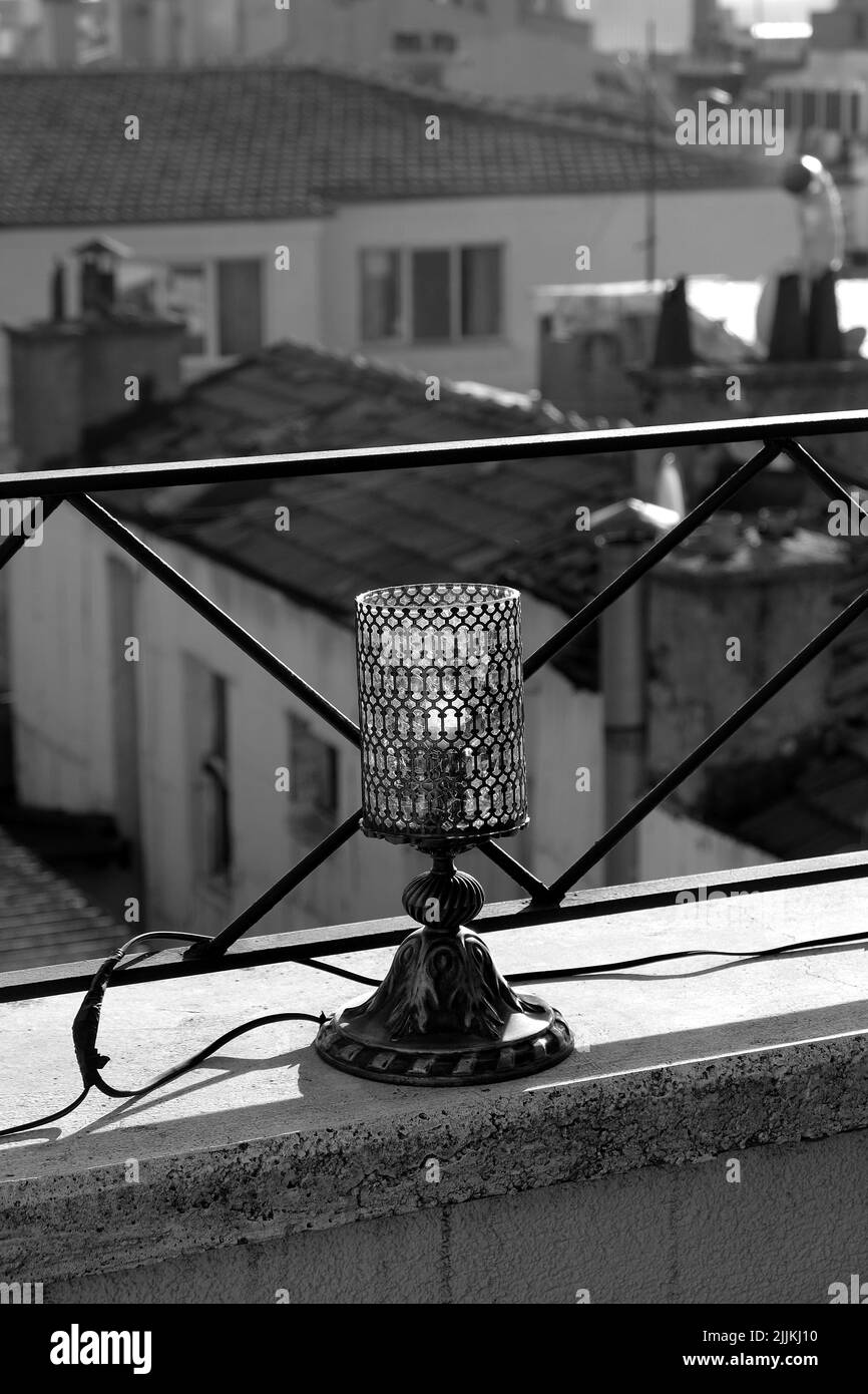 Una scala di grigi di un lampadario su una parete vicino alla ringhiera Foto Stock