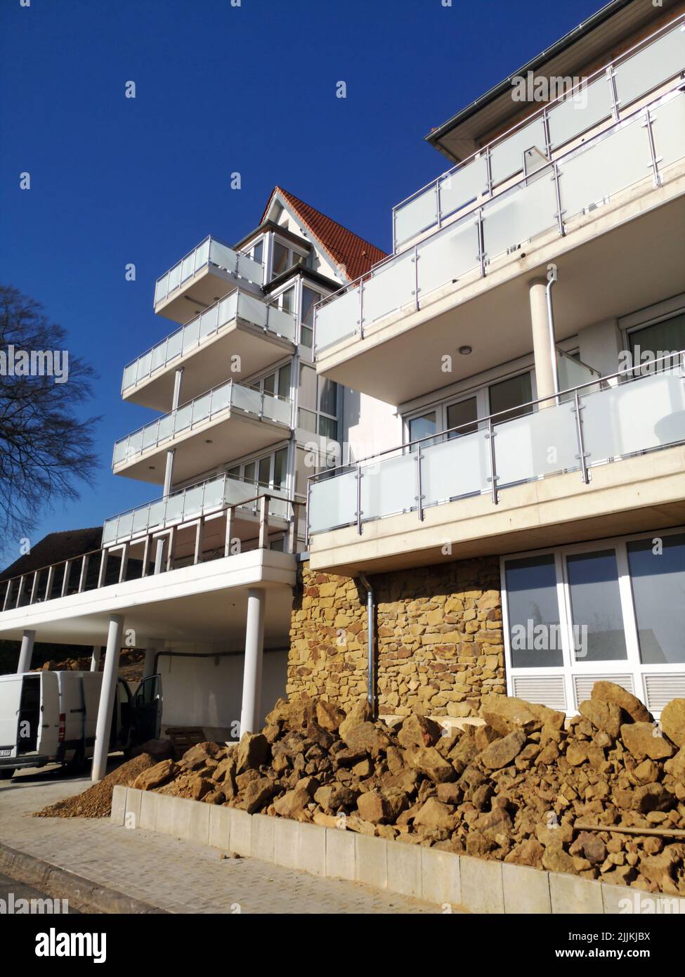 Un colpo verticale di un edificio con un parcheggio e balconi in una giornata di sole Foto Stock