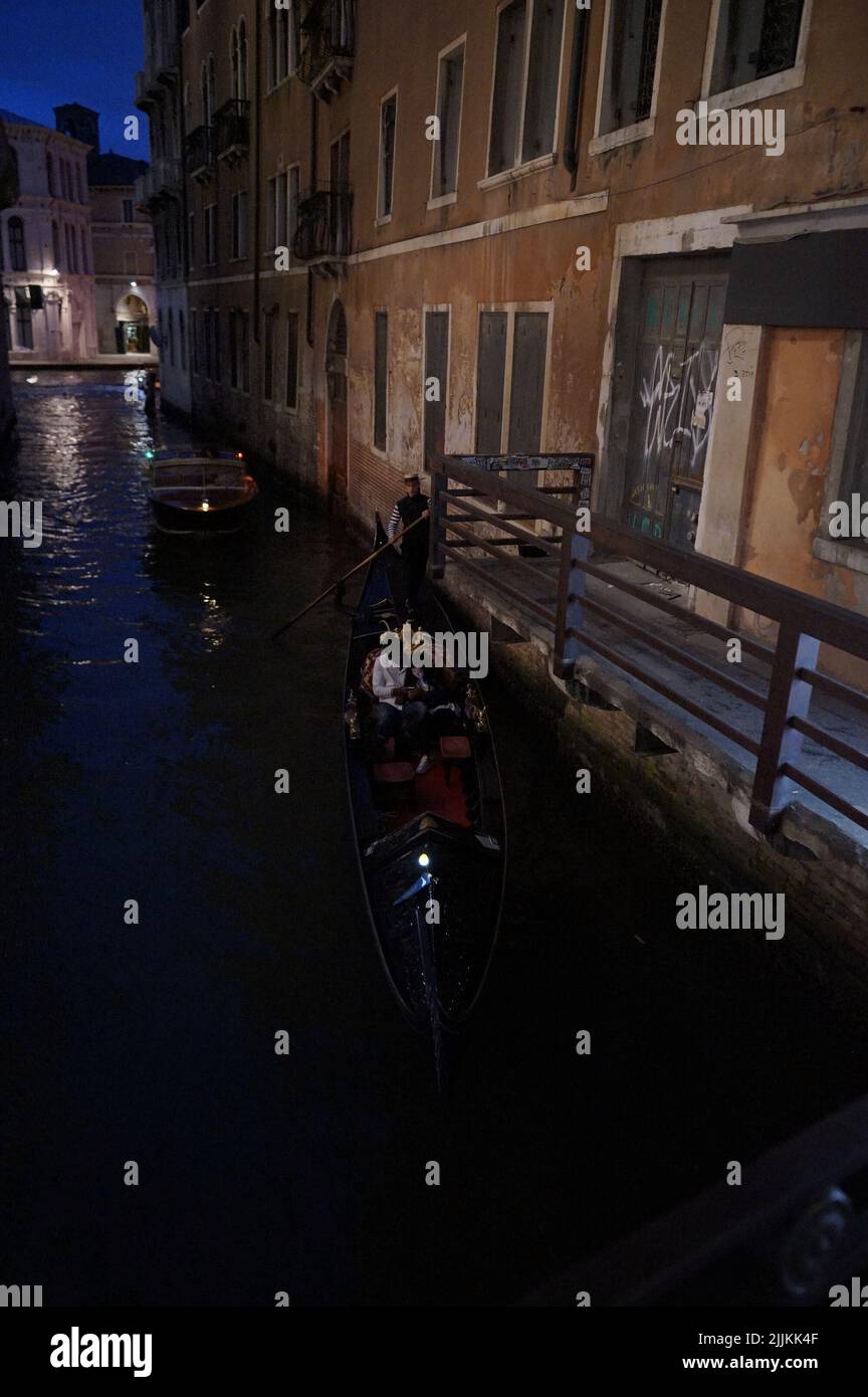 Un colpo verticale di gondole sul canale di notte a Venezia, Italia Foto Stock
