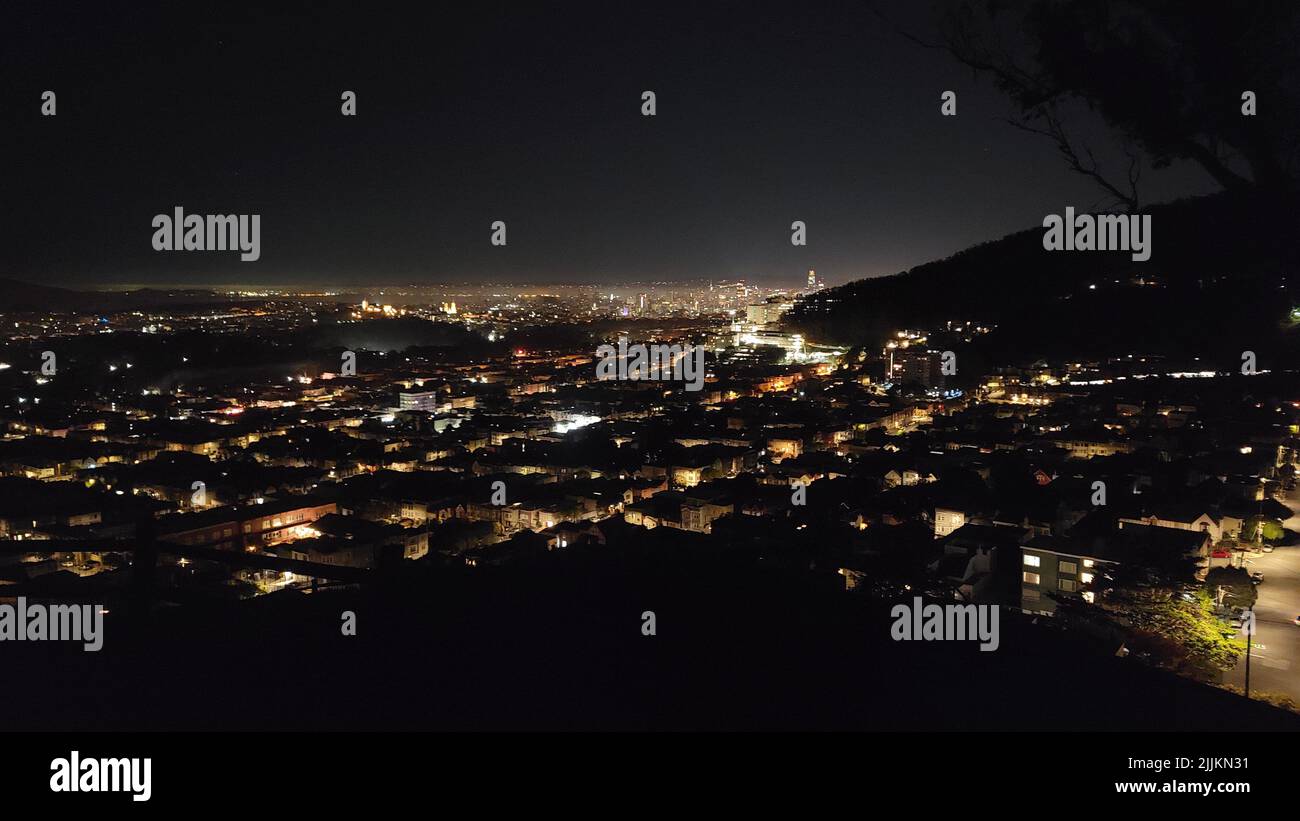 Un'immagine aerea di un paesaggio urbano con edifici con finestre illuminate di notte Foto Stock