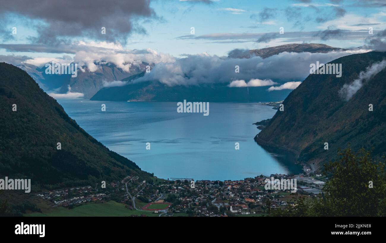 Una bella vista delle case e un lago circondato da montagne in Norvegia Foto Stock