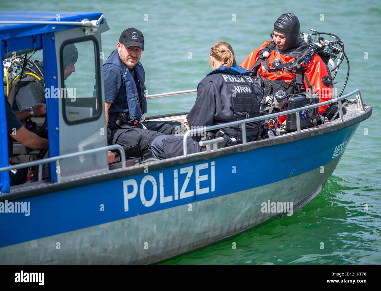 Porta Westfalica, Germania. 27th luglio 2022. Una barca della polizia con i subacquei dall'unità di immersione di Bochum naviga su un laghetto di ghiaia dove due persone non sono riuscito a surfare per motivi inspiegabili mentre nuotavano la domenica (24.07.2022). Secondo un portavoce del dipartimento dei vigili del fuoco, alcune parti del lago sono profonde circa 30 metri. Gli esperti della polizia ora vogliono cercare le due persone con una sonda subacquea. Credit: Lino Mirgeler/dpa/Alamy Live News Foto Stock