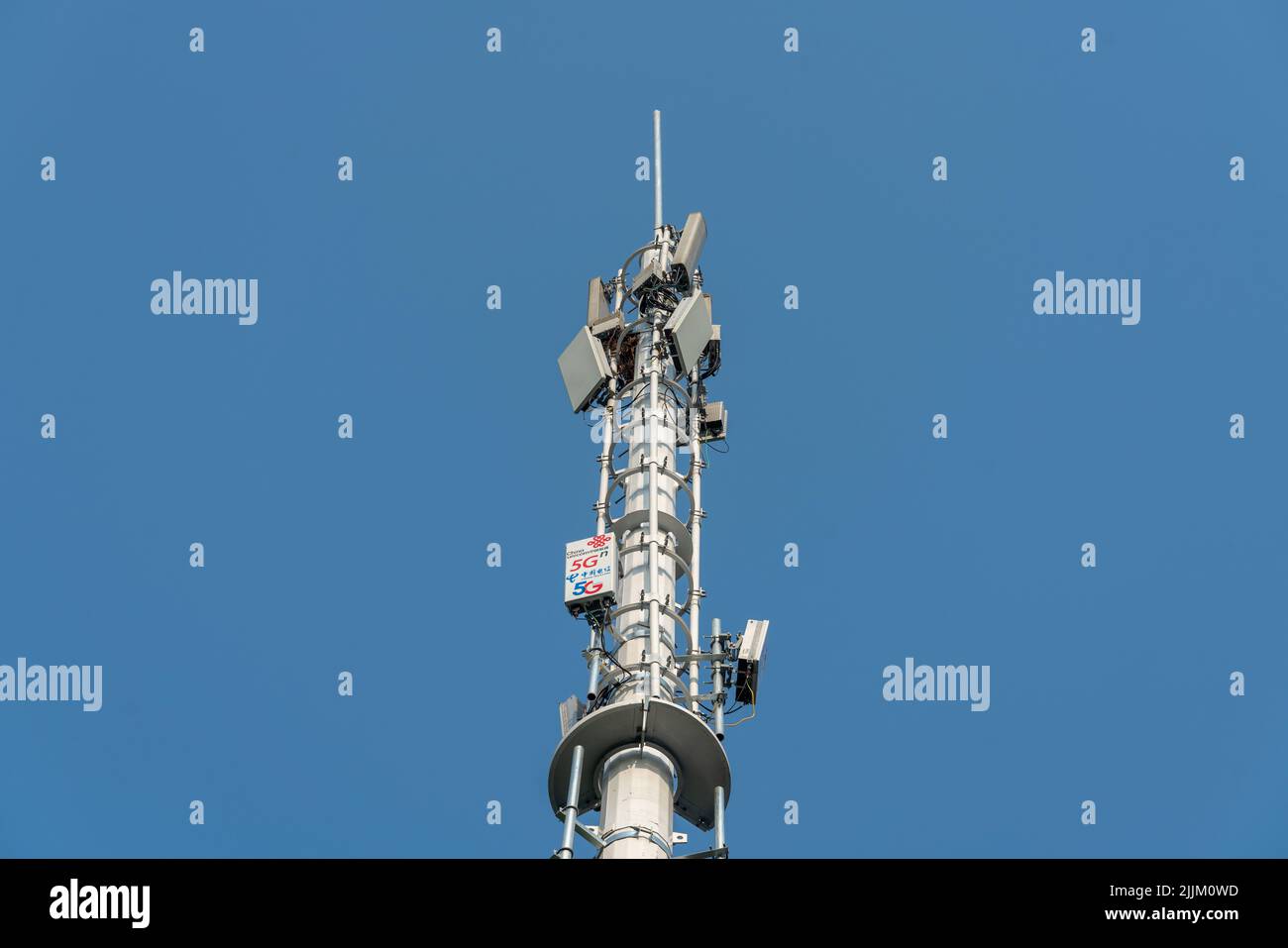 Un primo piano di torre di telecomunicazioni con 5G rete cellulare su sfondo blu cielo Foto Stock