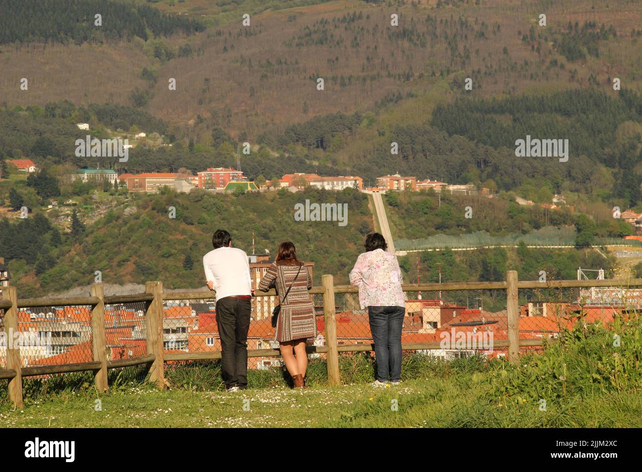 Una vista posteriore della gente che guarda la vista da una collina nei Paesi Baschi Foto Stock