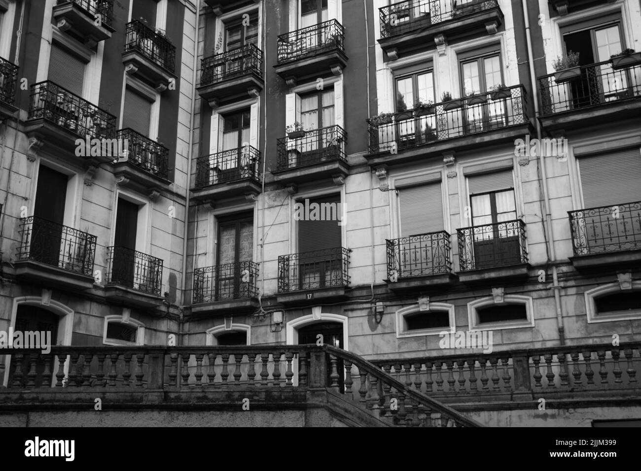 Un primo piano in scala di grigi di un edificio residenziale con balconate in vecchio stile a Bilbao, Spagna Foto Stock