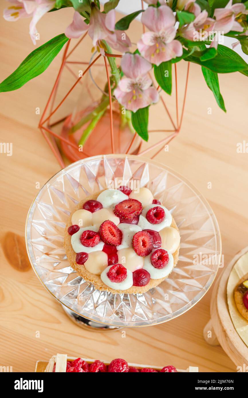 Pasticceria con panna e bacche. Cesti da forno con bacche fresche. Biscotti fatti in casa con lamponi. Foto Stock