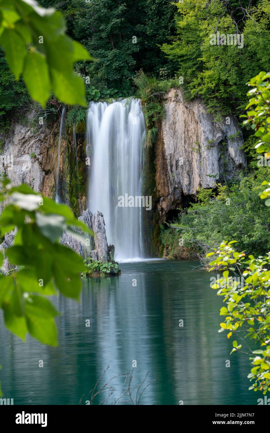 Un colpo verticale della bella cascata circondata da vegetazione verde. Foto Stock