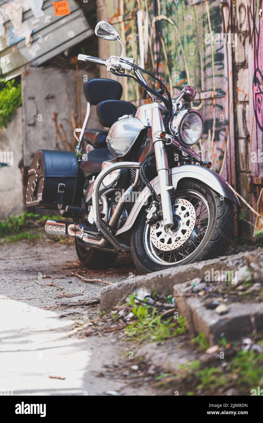 Una vista su una strada vecchia con una motocicletta parcheggiata in una giornata di sole Foto Stock