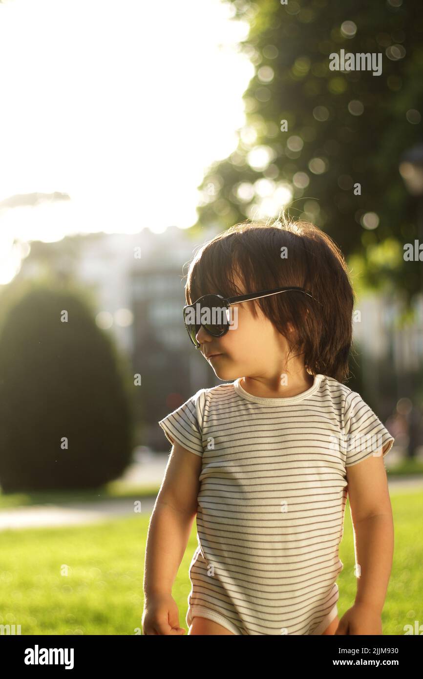 bambino ragazzo a 2 anni fa con occhiali da sole all'aperto Foto Stock