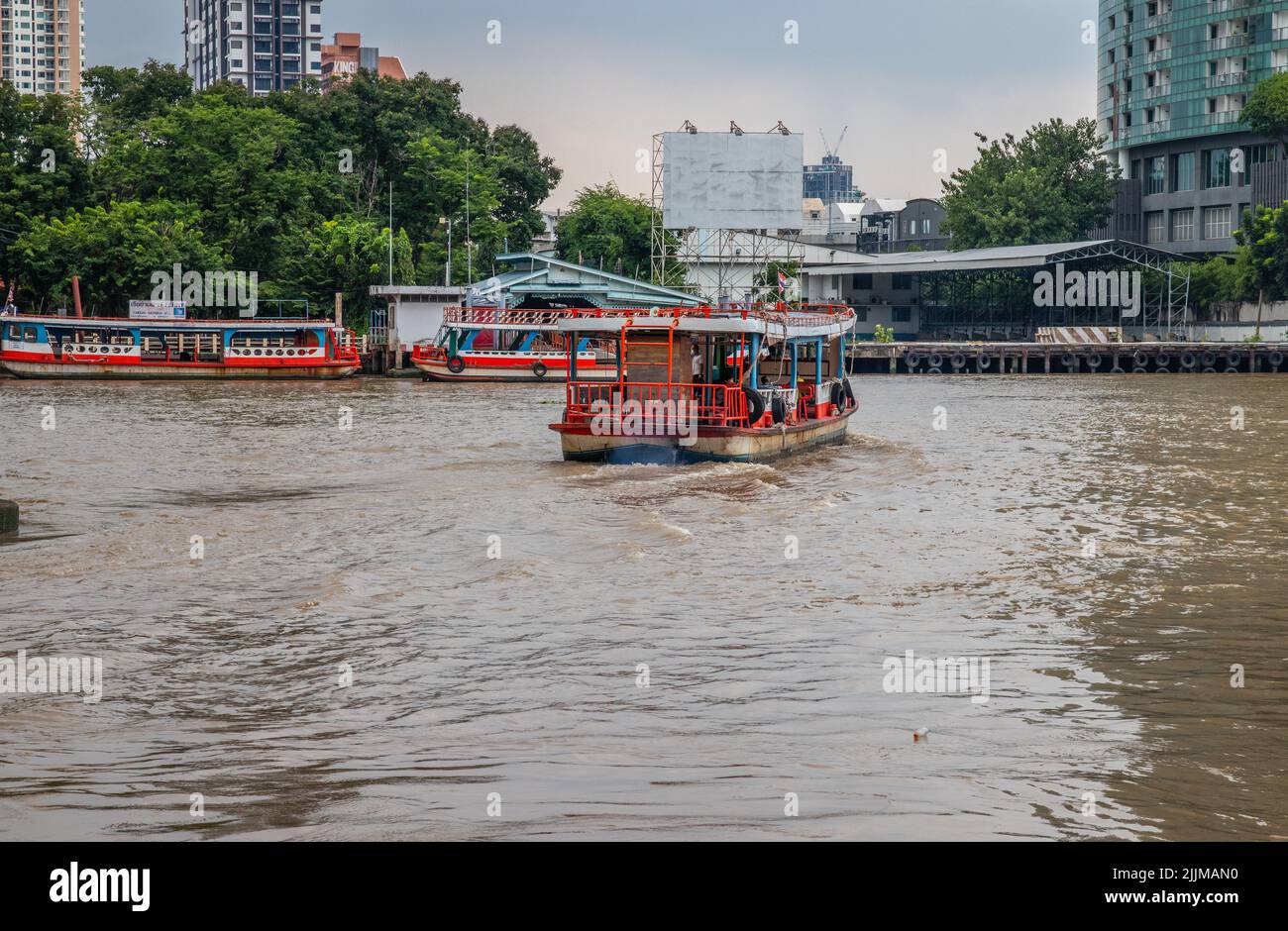 Una vista di un traghetto attraversa il fiume Chao Phraya dal molo di Sathorn a Bangkok Foto Stock