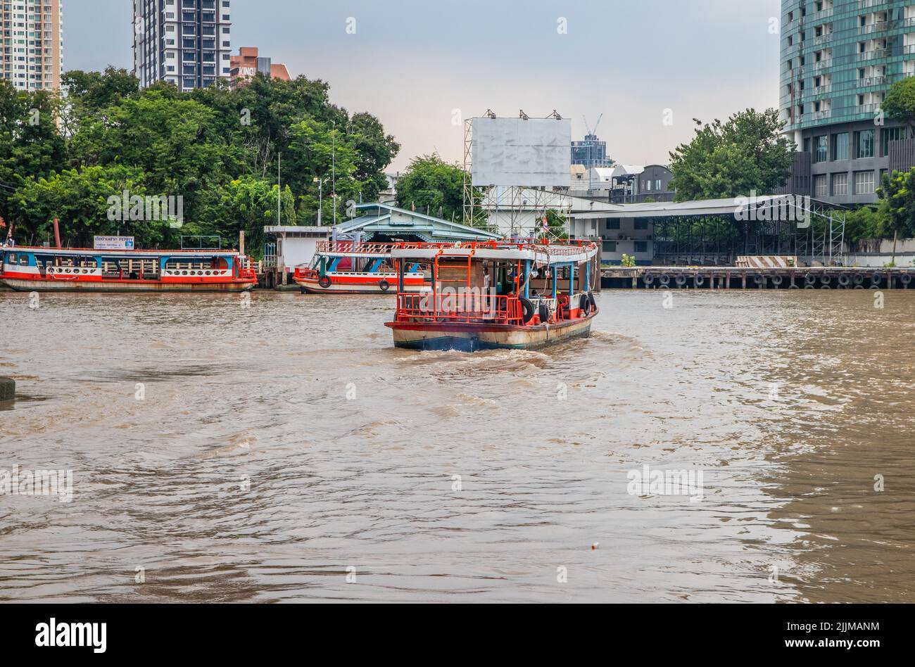 Una vista di un traghetto attraversa il fiume Chao Phraya dal molo di Sathorn a Bangkok Foto Stock
