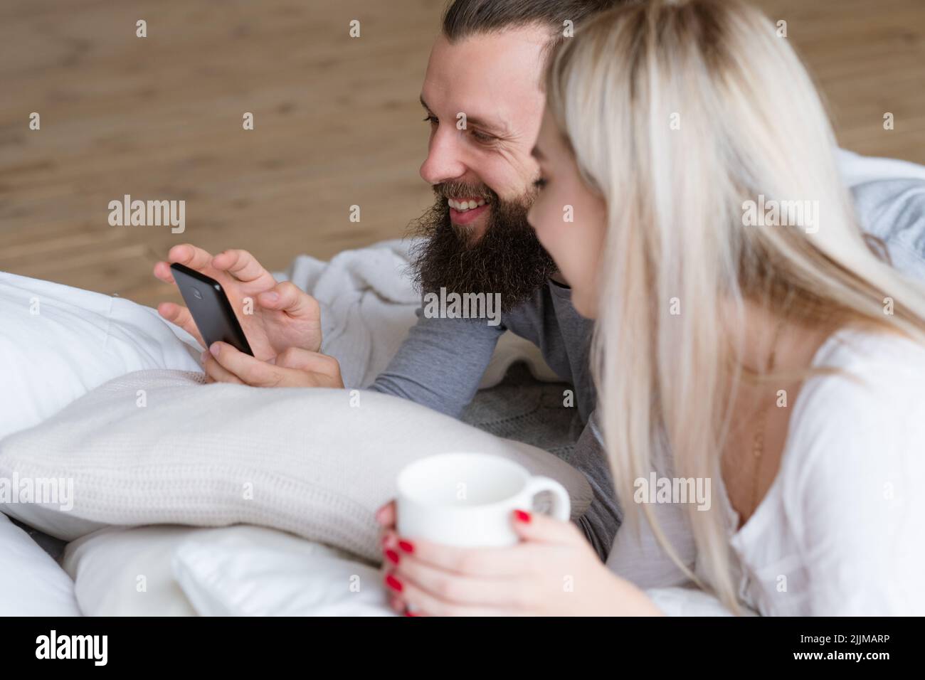 mattina coppia wake uomo donna tazza smartphone Foto Stock