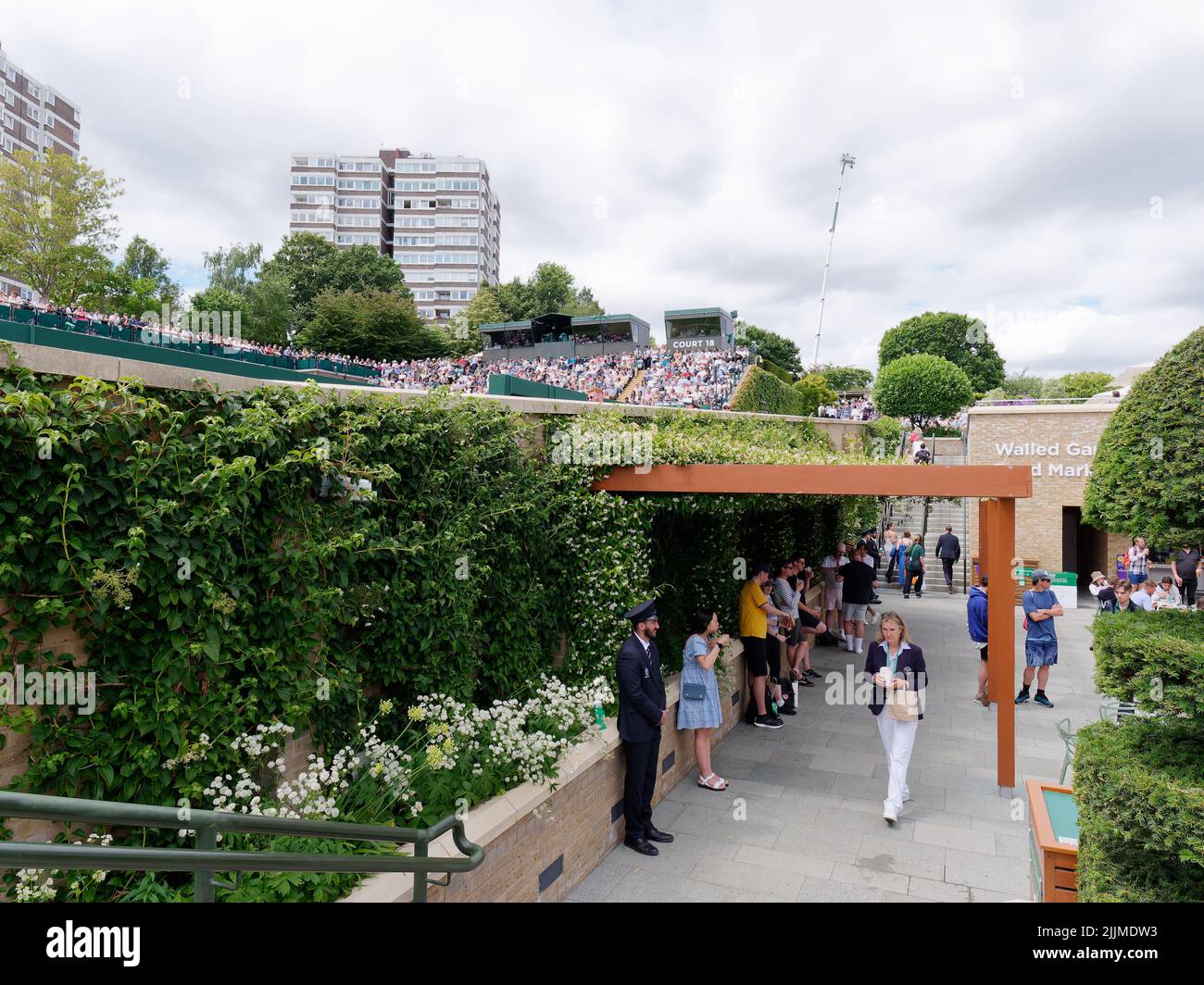 Wimbledon, Greater London, Inghilterra, luglio 02 2022: Wimbledon Tennis Championship. Cortile esterno pieno di spettatori e un vicino blocco di appartamenti. Persone Foto Stock