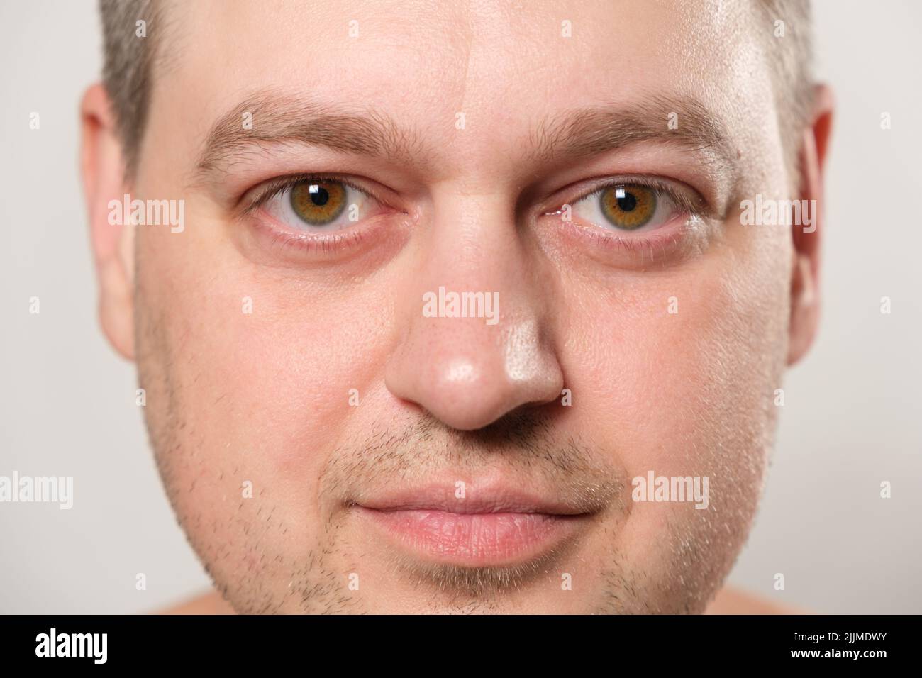 Il volto di un uomo caucasico di 36 anni con un primo piano di lui che guarda nella fotocamera. Foto Stock