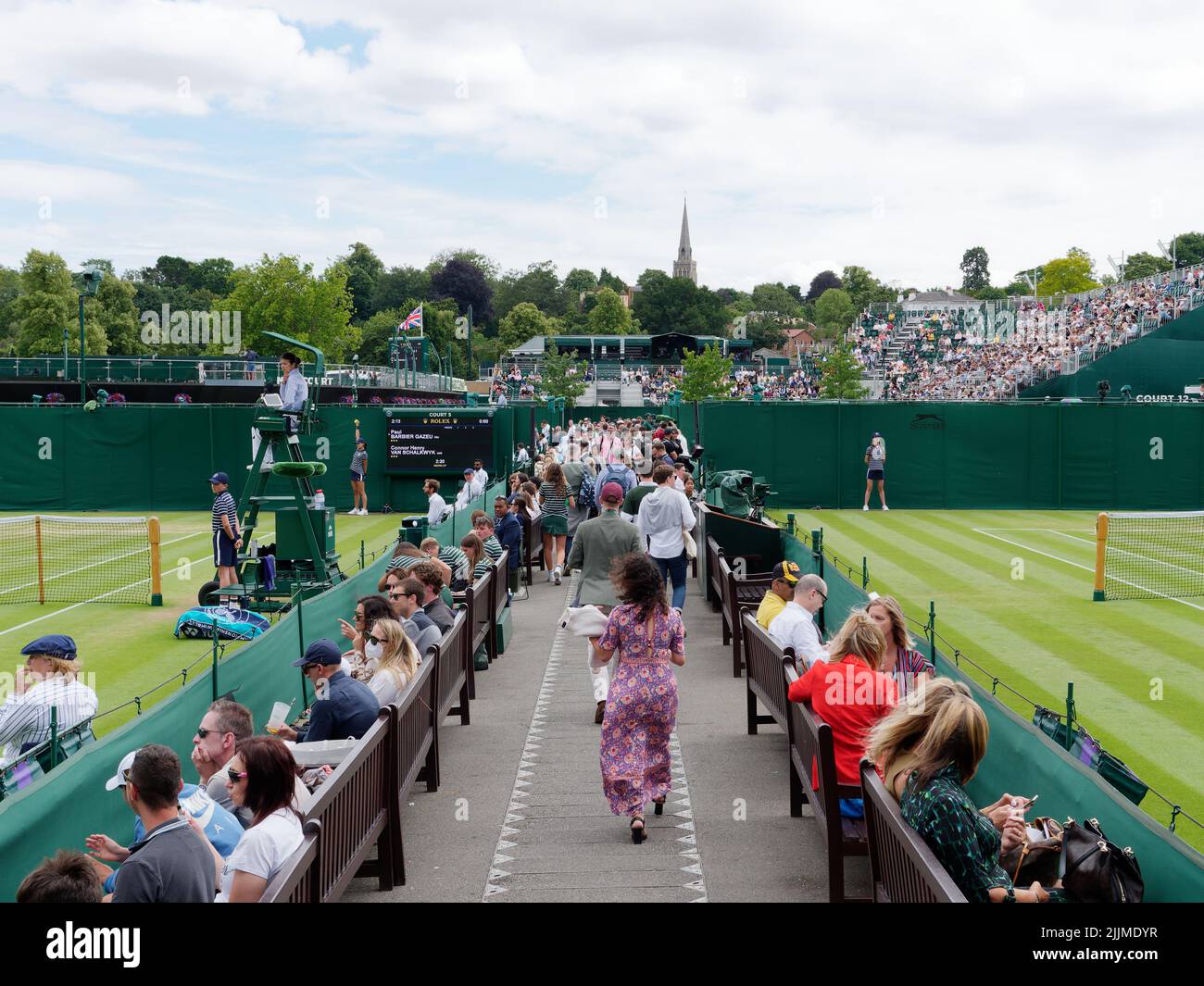 Wimbledon, Greater London, Inghilterra, luglio 02 2022: Wimbledon Tennis Championship. Passerella tra campi esterni, spettatori e un gommetto e palla ragazzo Foto Stock