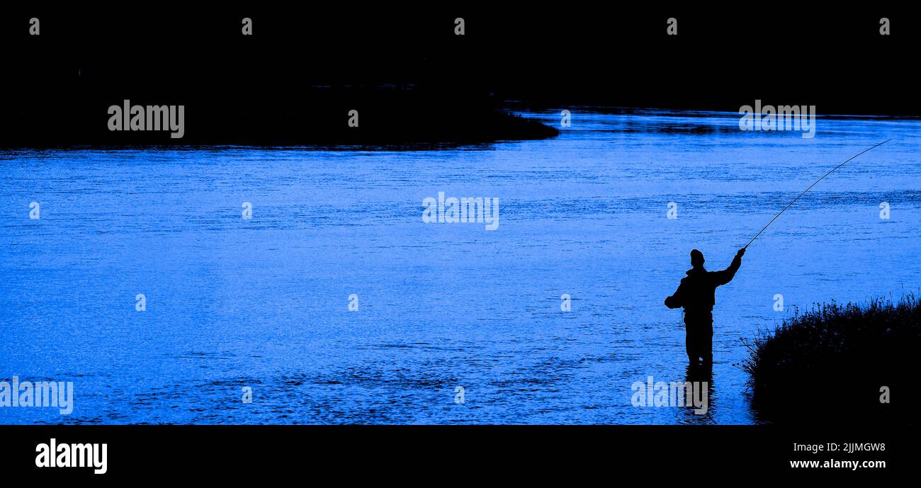 Flyfisherman pescatore a mosca la pesca sul fiume con Tetons in background Foto Stock