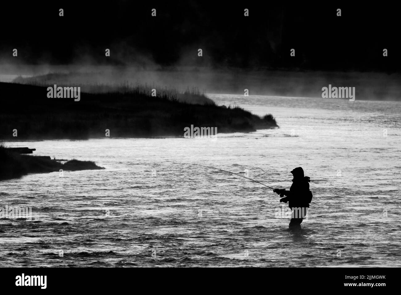 Silhouette della pesca a mosca rod reel in fiume con la luce del sole dorato Foto Stock