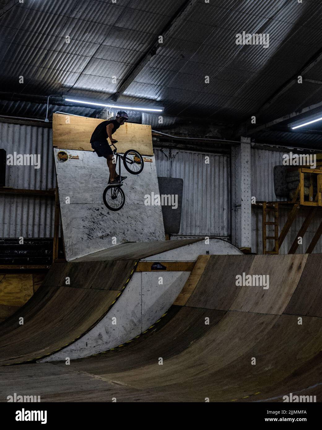 Un ciclista che fa un trucco acrobatico in un parco coperto BMX bici salta lo sport a Rosario, Argentina Foto Stock