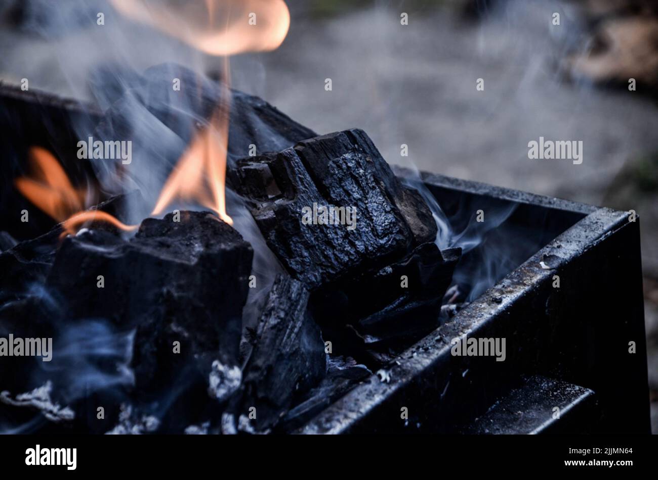 Un primo piano dei carboni neri accesi nella griglia del barbecue in ferro nero Foto Stock