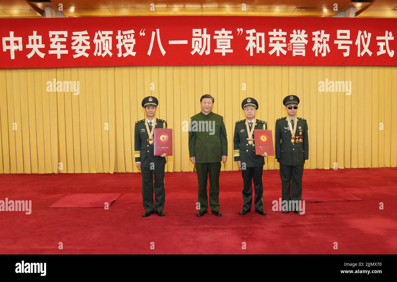 Pechino, Cina. 27th luglio 2022. Il presidente cinese Xi Jinping, anche segretario generale del Comitato Centrale del Partito Comunista Cinese e presidente della Commissione militare Centrale, scatta foto con i destinatari della Medaglia del 1 agosto a Pechino, capitale della Cina, il 27 luglio 2022. XI mercoledì ha presentato la Medaglia del 1 agosto a tre militari e ha conferito una bandiera onoraria ad un battaglione militare per il loro eccezionale servizio in vista del 95th anniversario della fondazione dell'Esercito popolare di liberazione cinese. Credit: Li Gang/Xinhua/Alamy Live News Foto Stock