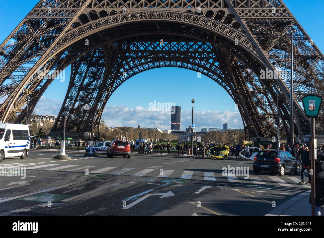 Alcuni turisti che si trovano sotto la torre Eiffel di Parigi si meravigliano dell'ingegneria. Foto Stock