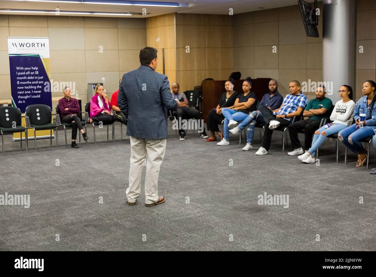 L'educatore che istruisce diversi studenti adulti sulla finanza personale a Johannesburg, Sudafrica Foto Stock