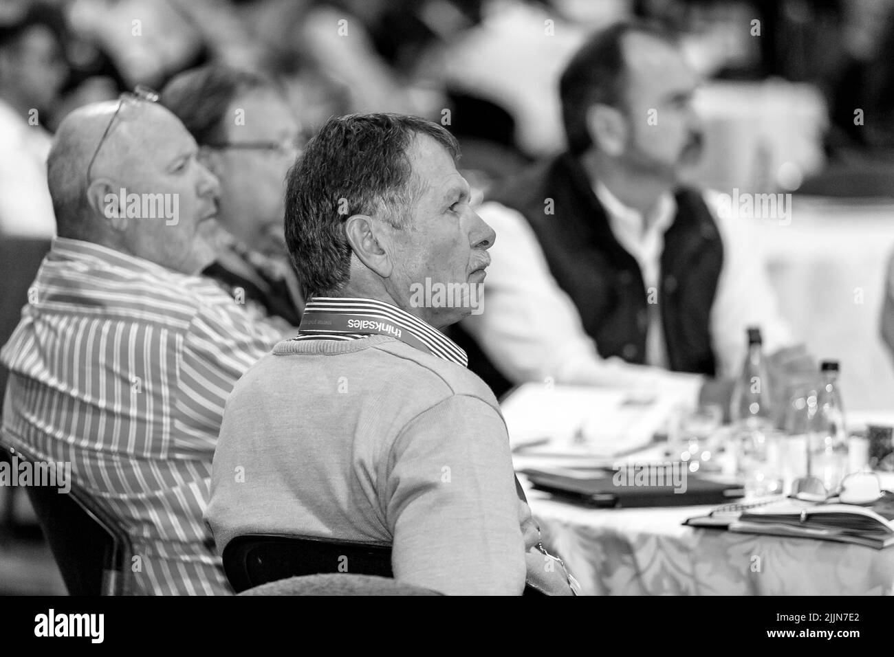 Una scala di grigi di delegati che partecipano a un convegno di vendita in un grande centro congressi a Johannesburg, Sudafrica Foto Stock