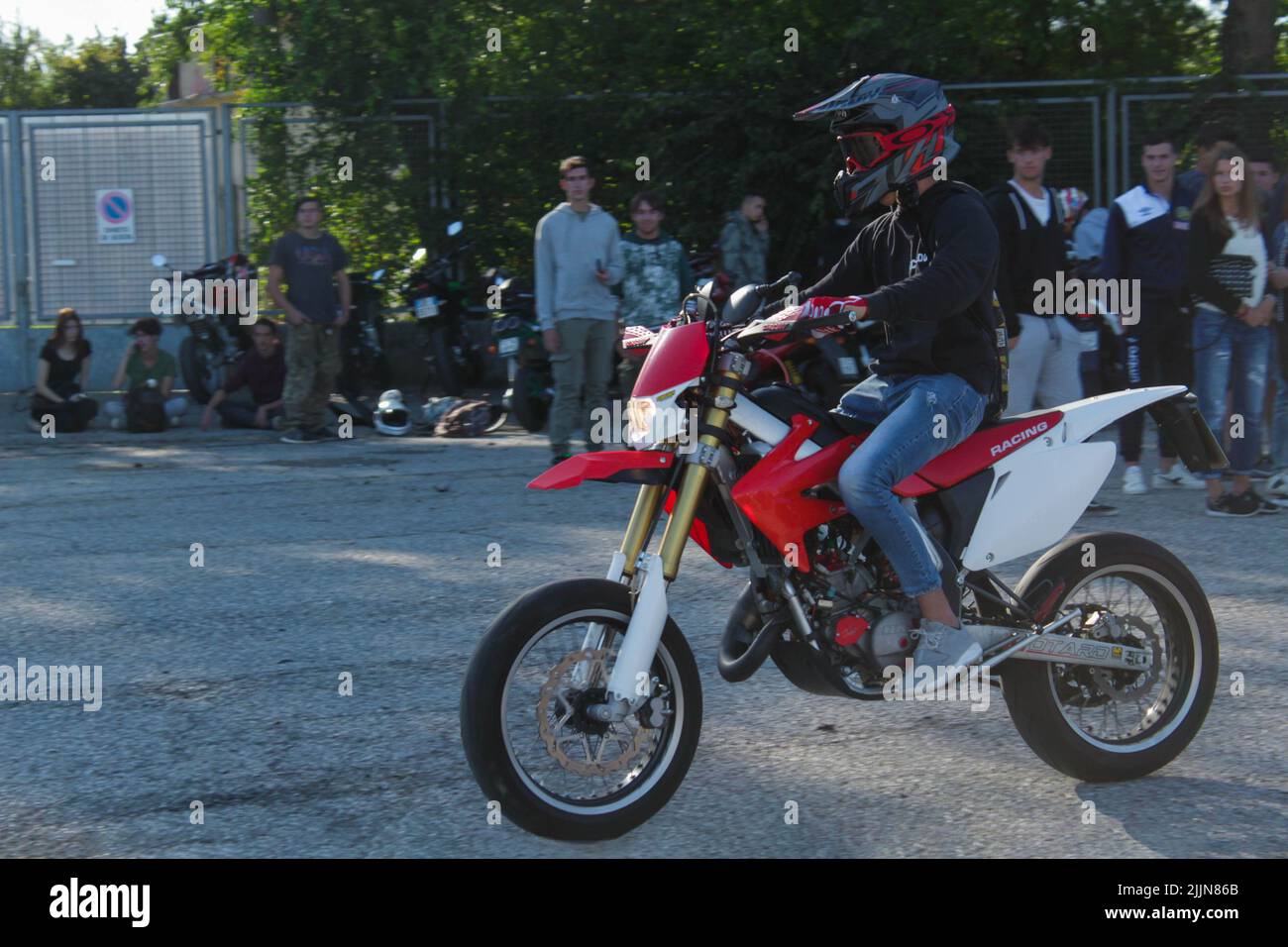 Un motociclista maschile che indossa un casco e guida la sua moto durante una competizione Foto Stock