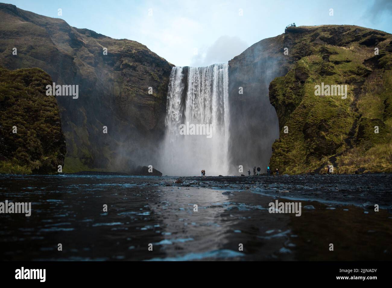 Una vista panoramica della cascata di Skogafoss sul fiume Skoga contro il cielo blu nell'Islanda meridionale Foto Stock