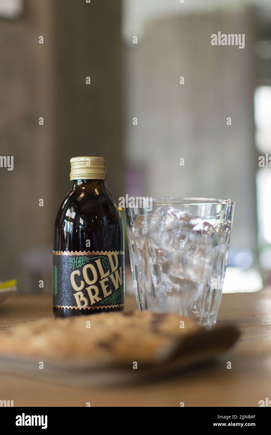 Un primo piano di caffè Cold Brew e un bicchiere con cubetti di ghiaccio su un tavolo di legno in una caffetteria a Novi Sad, Serbia Foto Stock