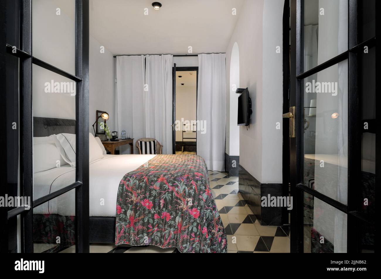 Una camera da letto interna con un design eclettico e un letto confortevole. Foto Stock