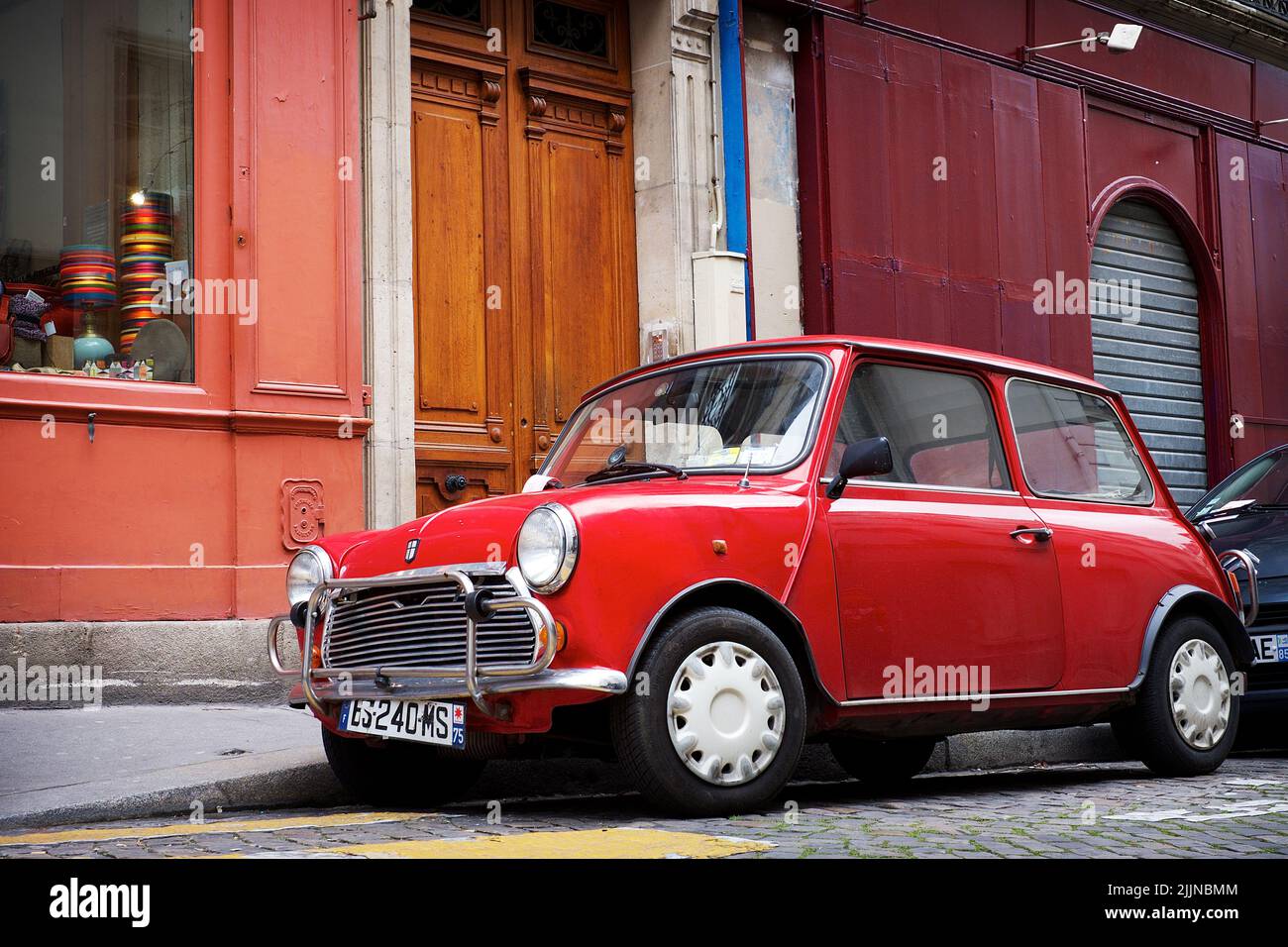 Un vecchio parcheggio rosso Cooper sul lato della strada a Londra Foto Stock