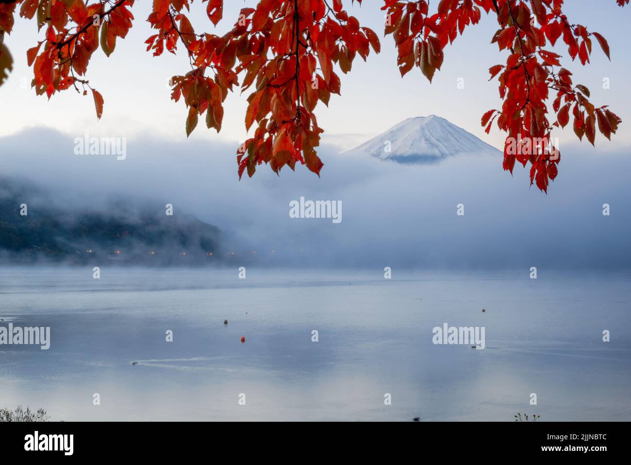 Mt. Fuji sopra il Lago Kawaguchi, Giappone con nebbia che rotola all'alba durante la stagione autunnale. Foto Stock