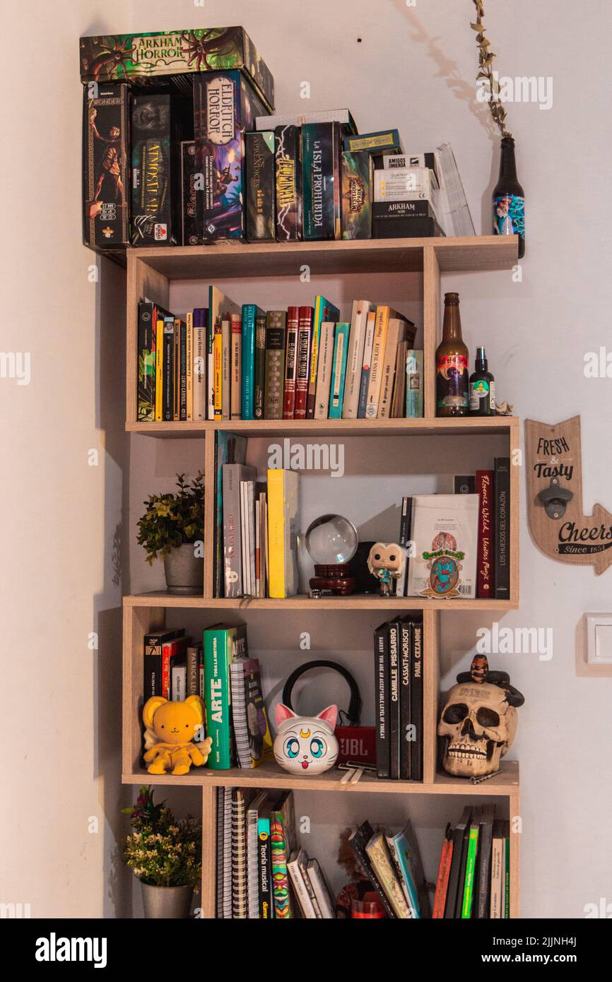 Una foto verticale di una libreria con oggetti e giocattoli vintage Foto Stock