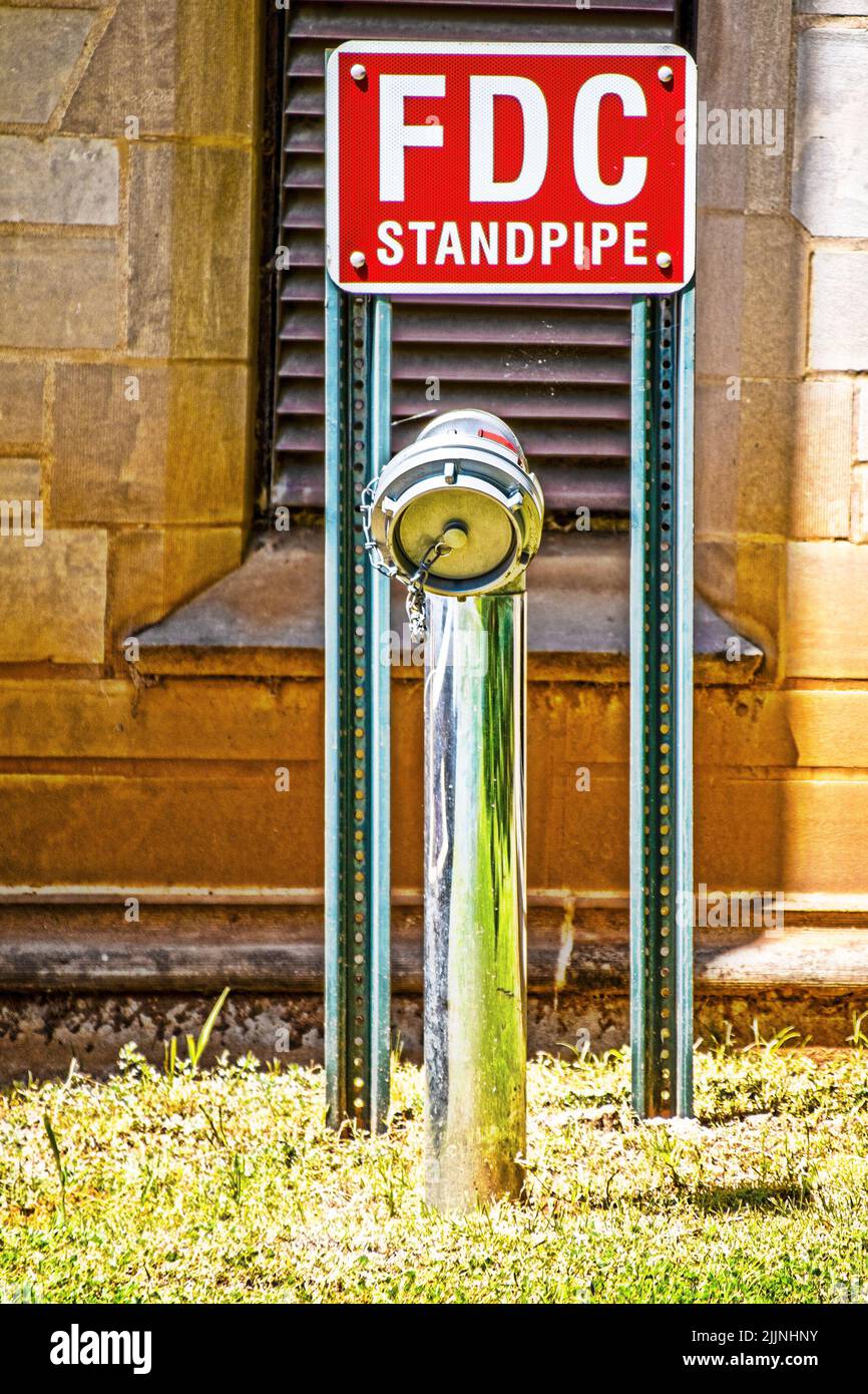FDC Fire Department Connection Standpipe da vecchio edificio roccioso - parte di un impianto sprinkler antincendio e consente a un reparto antincendio che risponde di integrare Foto Stock FDC Fire Department Connection Standpipe da vecchio edificio roccioso - parte di un impianto sprinkler antincendio e consente a un reparto antincendio che risponde di integrare Foto Stock