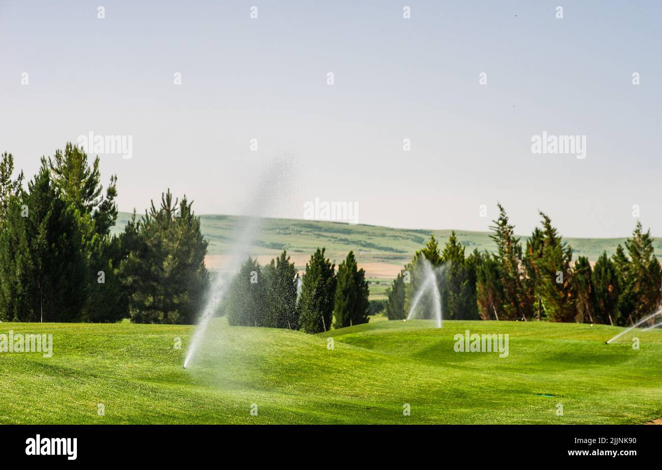 Sprinkler ad acqua che annaffiano l'erba su un campo da golf in estate, Kakheti, Tusheti, Georgia Foto Stock
