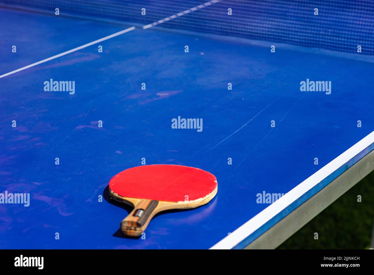 Primo piano di una mazza da ping-pong su un tavolo da ping-pong Foto Stock
