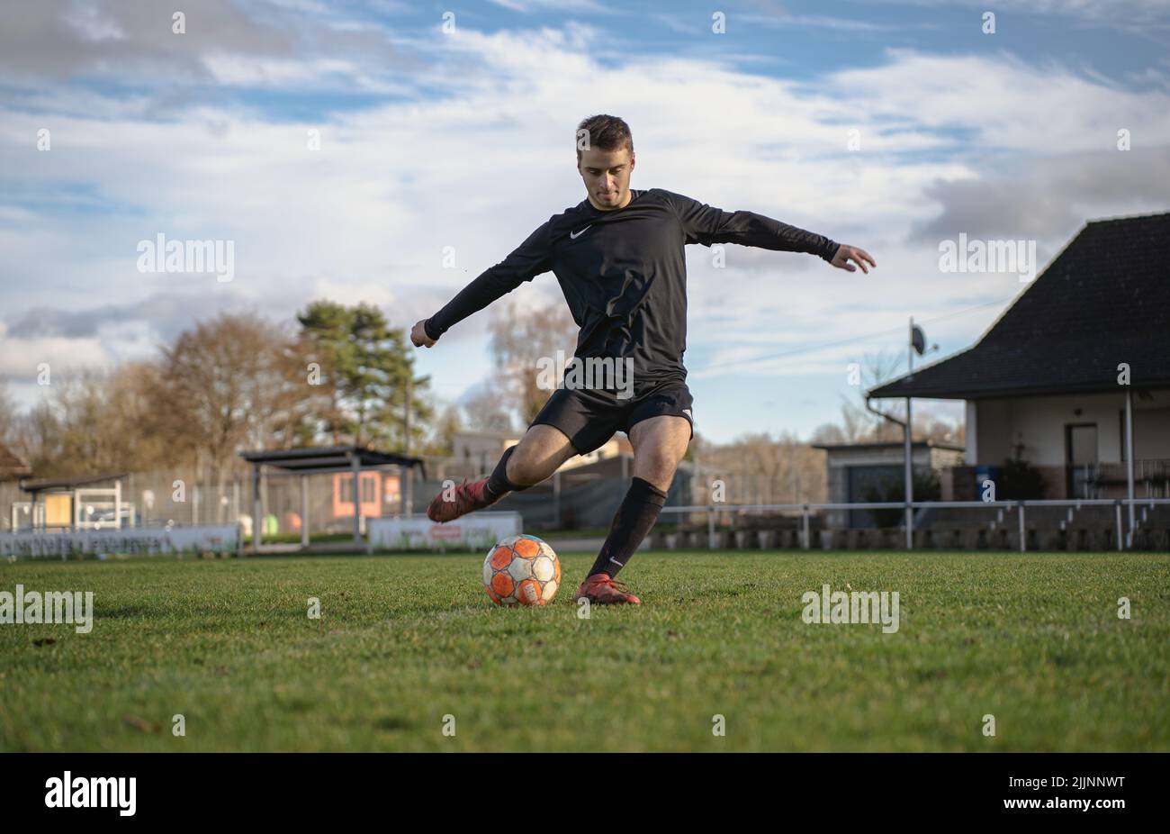 Una vista del giocatore di calcio tedesco calcia la palla nel campo Foto Stock