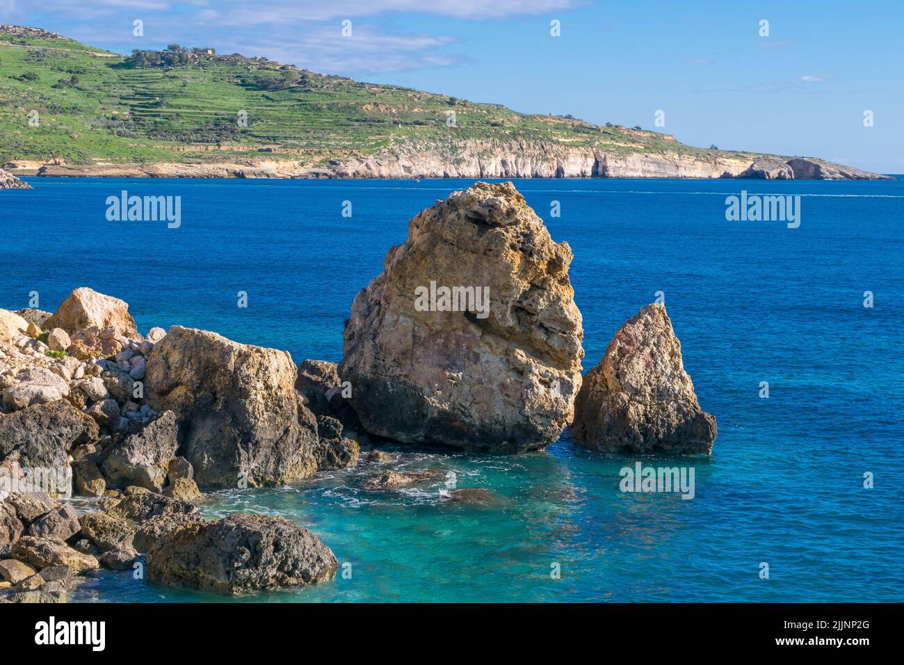 Una serie di massi e rocce calcaree, accumulati l'uno sull'altro lungo la costa di Gozo, Malta, a causa delle intemperie e dell'erosione del mare costiero. Foto Stock