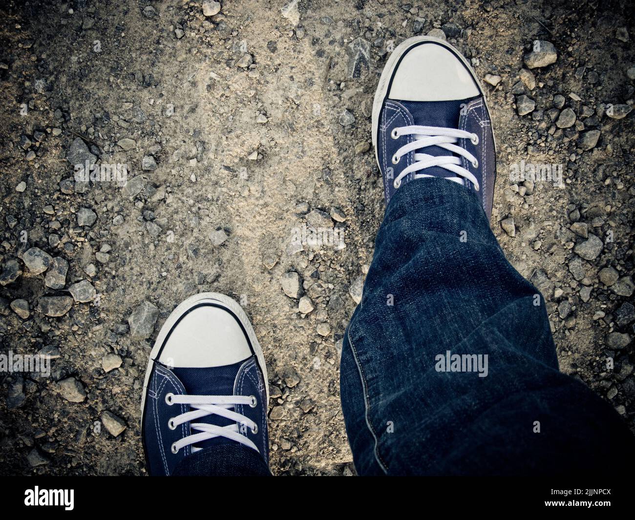 Una foto dall'alto di una persona che cammina con scarpe bianche e blu Foto Stock