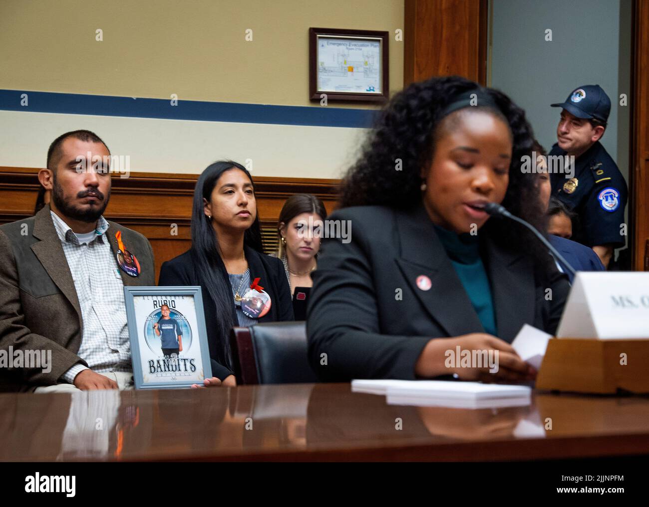 Un ufficiale di polizia del Campidoglio degli Stati Uniti, a destra, si appresta a entrare nella sala uditiva mentre Felix Rubio, a sinistra, e Kimberly Rubio, secondo da sinistra, la cui figlia Alexandria Rubio era uno dei bambini uccisi da un uomo da armi alla Robb Elementary School di Uvalde, Texas, ascoltano le osservazioni di Antonia Okafor, Direttore nazionale dell'Outreach delle Donne presso i proprietari di Gun d'America, secondo da destra, durante un'audizione della Camera Committee on Oversight and Reform "Evining the Practices and profits of Gun Manufacturers" nell'edificio Rayburn House Office di Washington, DC, 27 luglio 2022. Credit: Rod Lamkey/CNP/Sipa USA Foto Stock