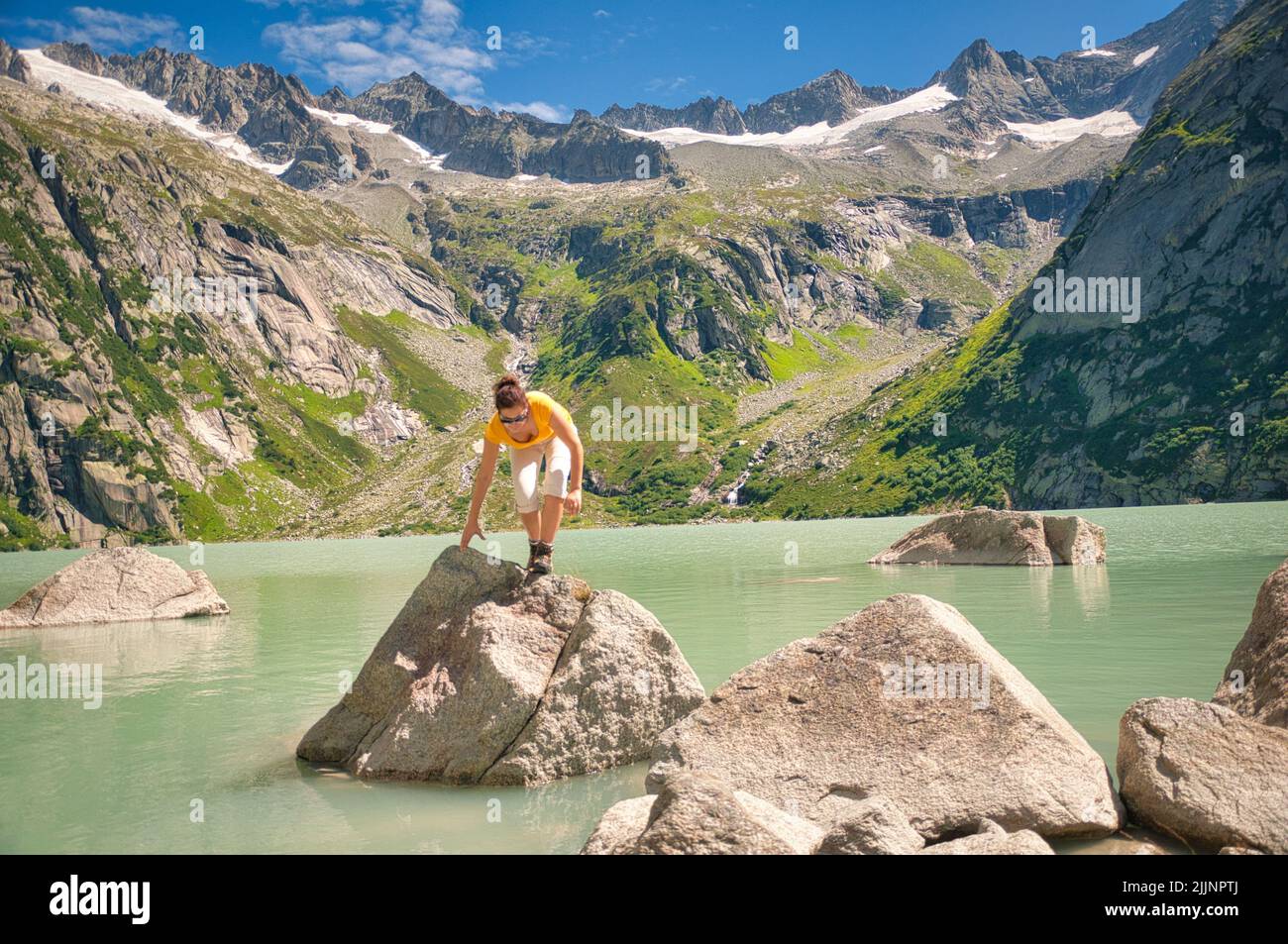 Donna che si arrampica sulle rocce a Gelmersee, Guttanen, Svizzera Foto Stock