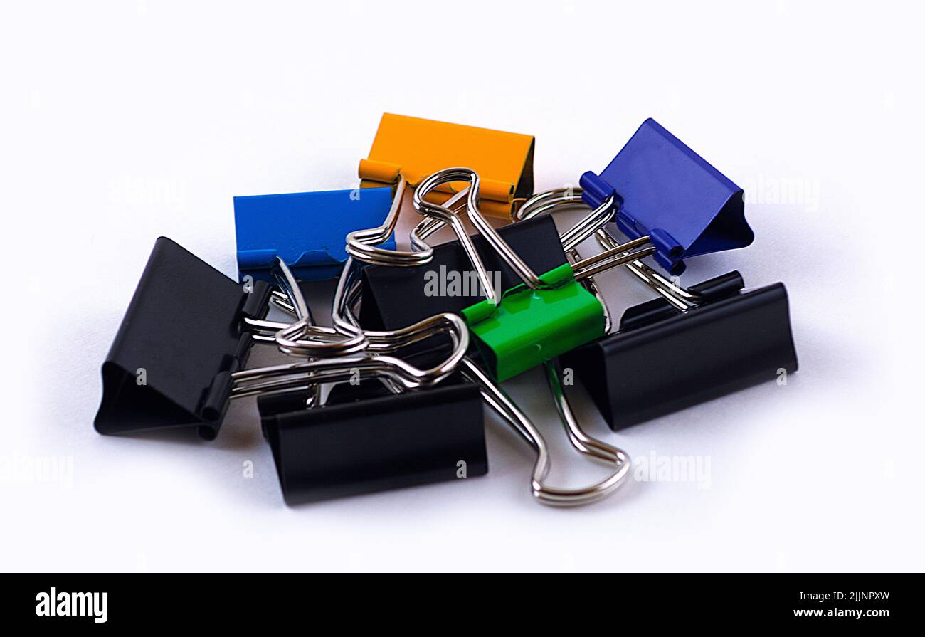 Un primo piano di graffette metalliche in carta, isolate su sfondo bianco Foto Stock