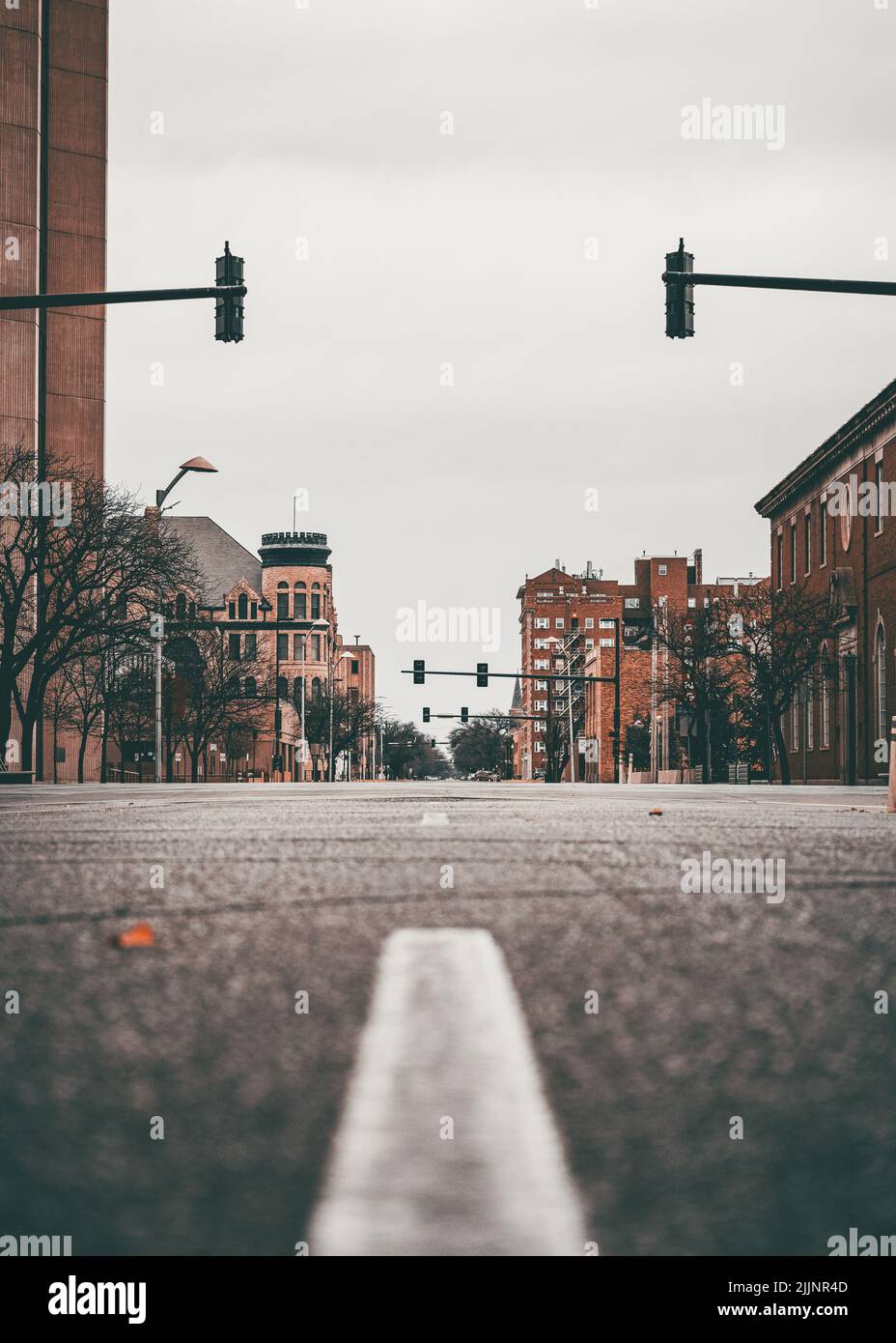 Un'immagine verticale dell'esterno di una città catturata da una strada asfaltata in toni modici Foto Stock